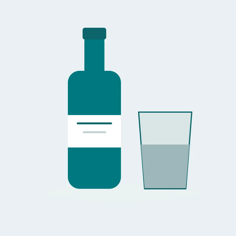A tall bottle with a plain label beside a half-filled glass